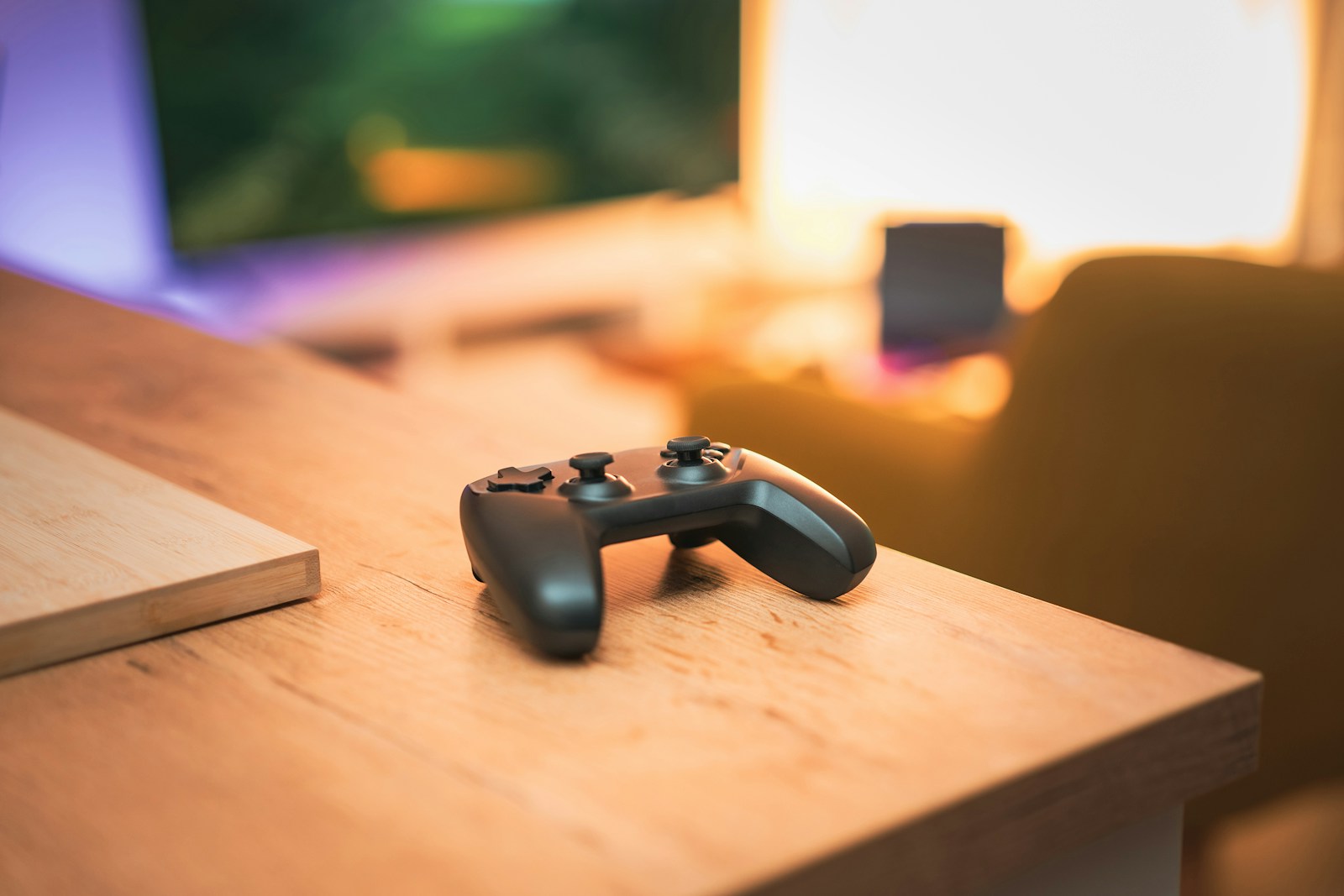 Control de videojuegos sobre un escritorio de madera con luz cálida