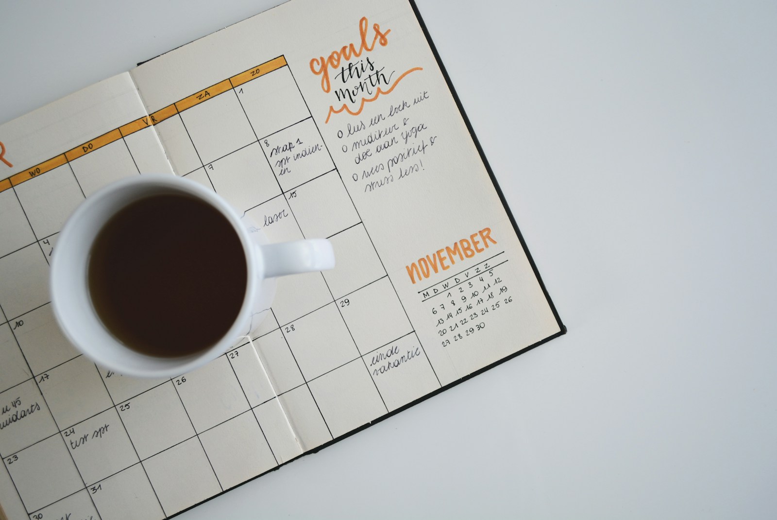 Agenda mensual abierta junto a una taza de café